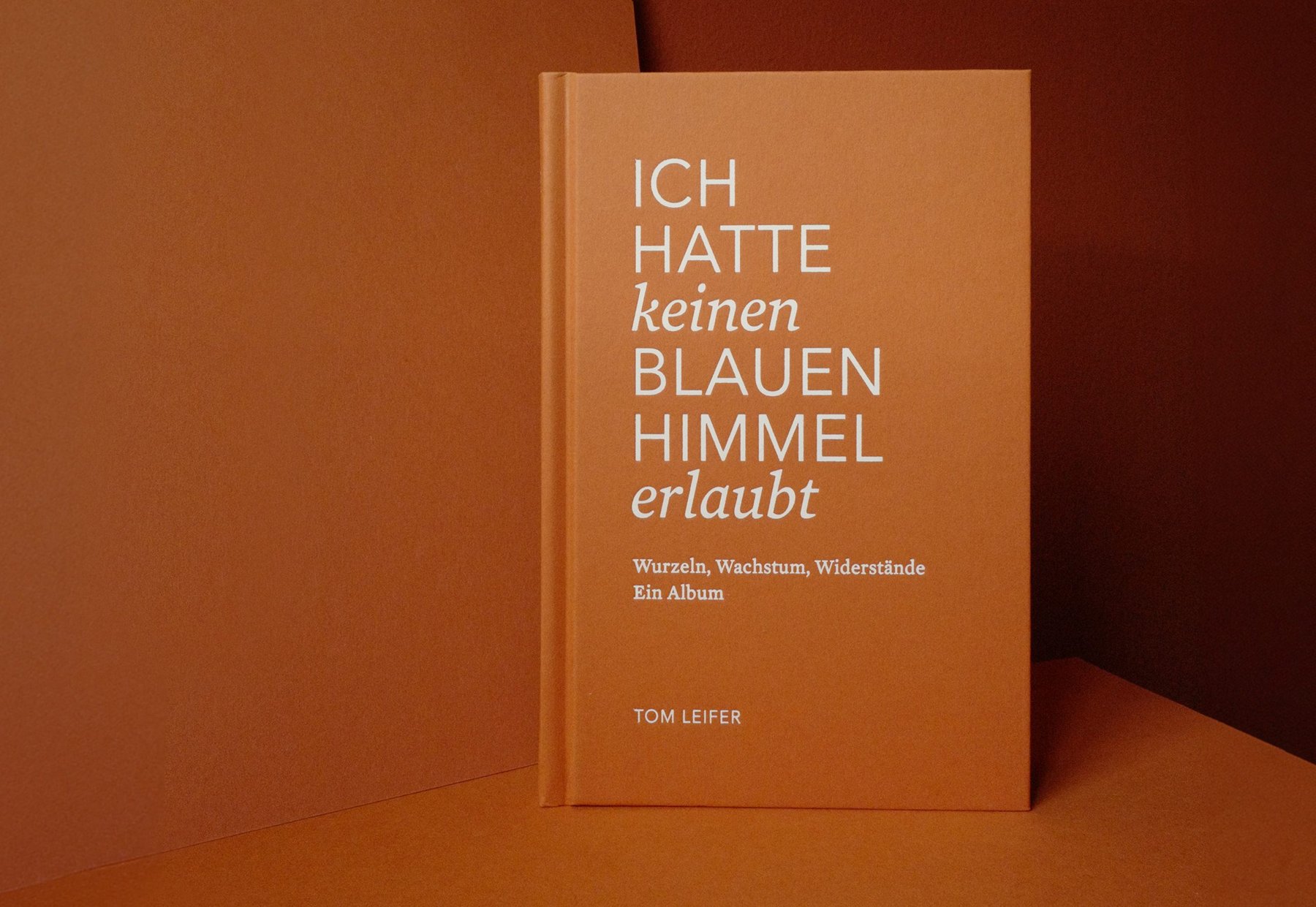 Buch „Ich hatte keinen blauen Himmel erlaubt“ vor orangefarbenem Hintergrund